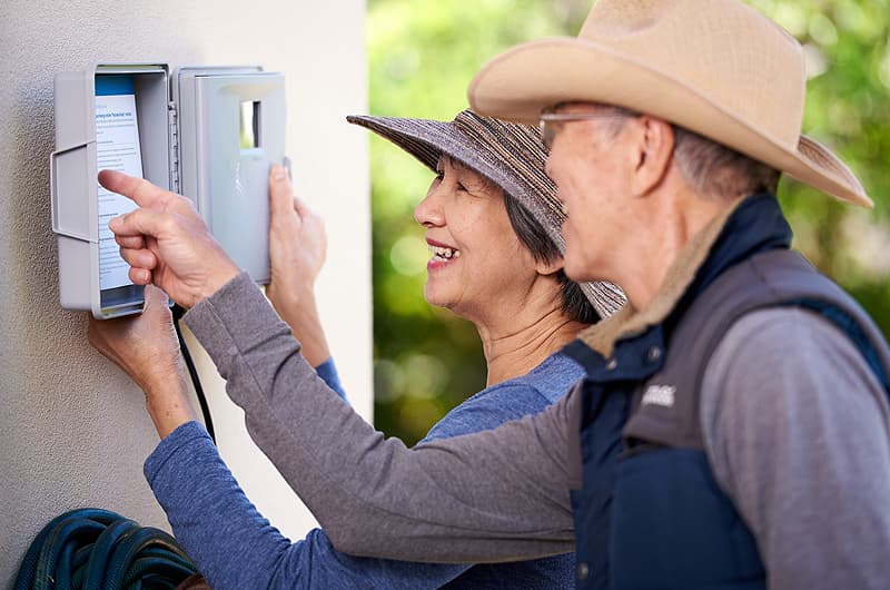 Couple checking their irrigation controller