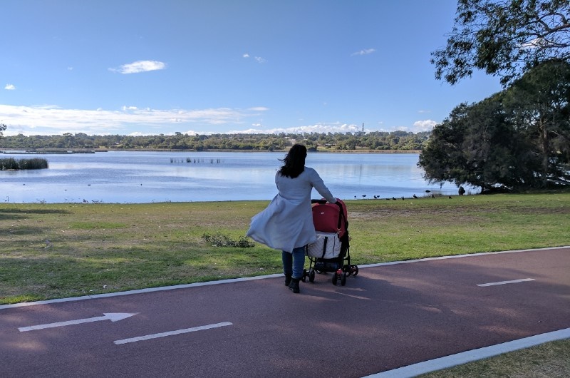 Image of lady walking with a pram by the water at Picnic Cove Park in Joondalup