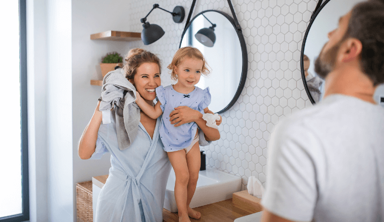 Young family in bathroom throwing a towel